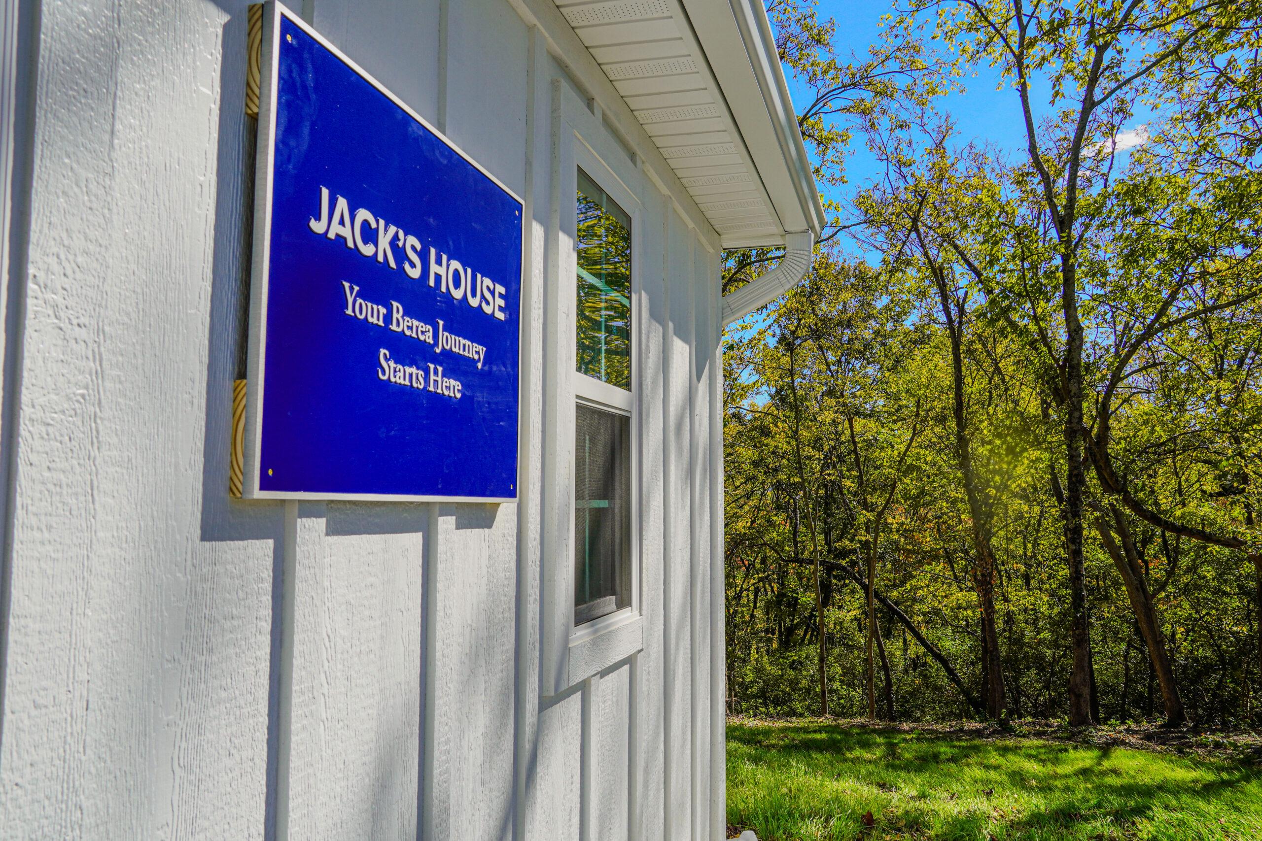 A blue sign on the front of Jack's House that reads 'Jack's House Your Berea Journey Starts Here."