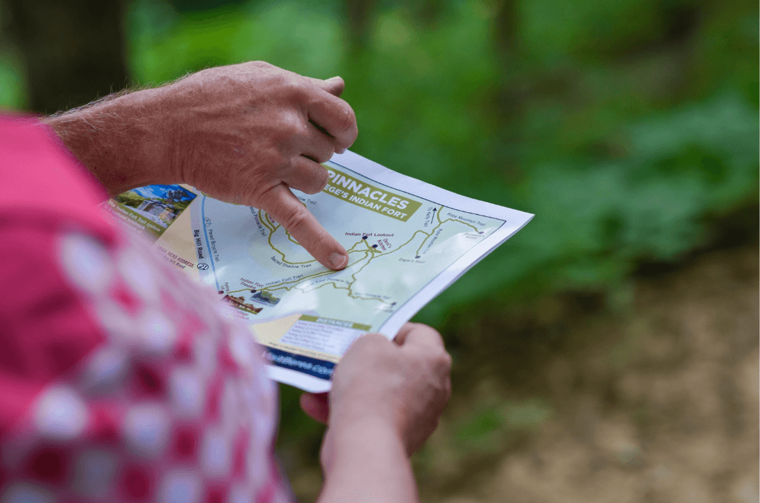 Hand pointing to a dot on the map